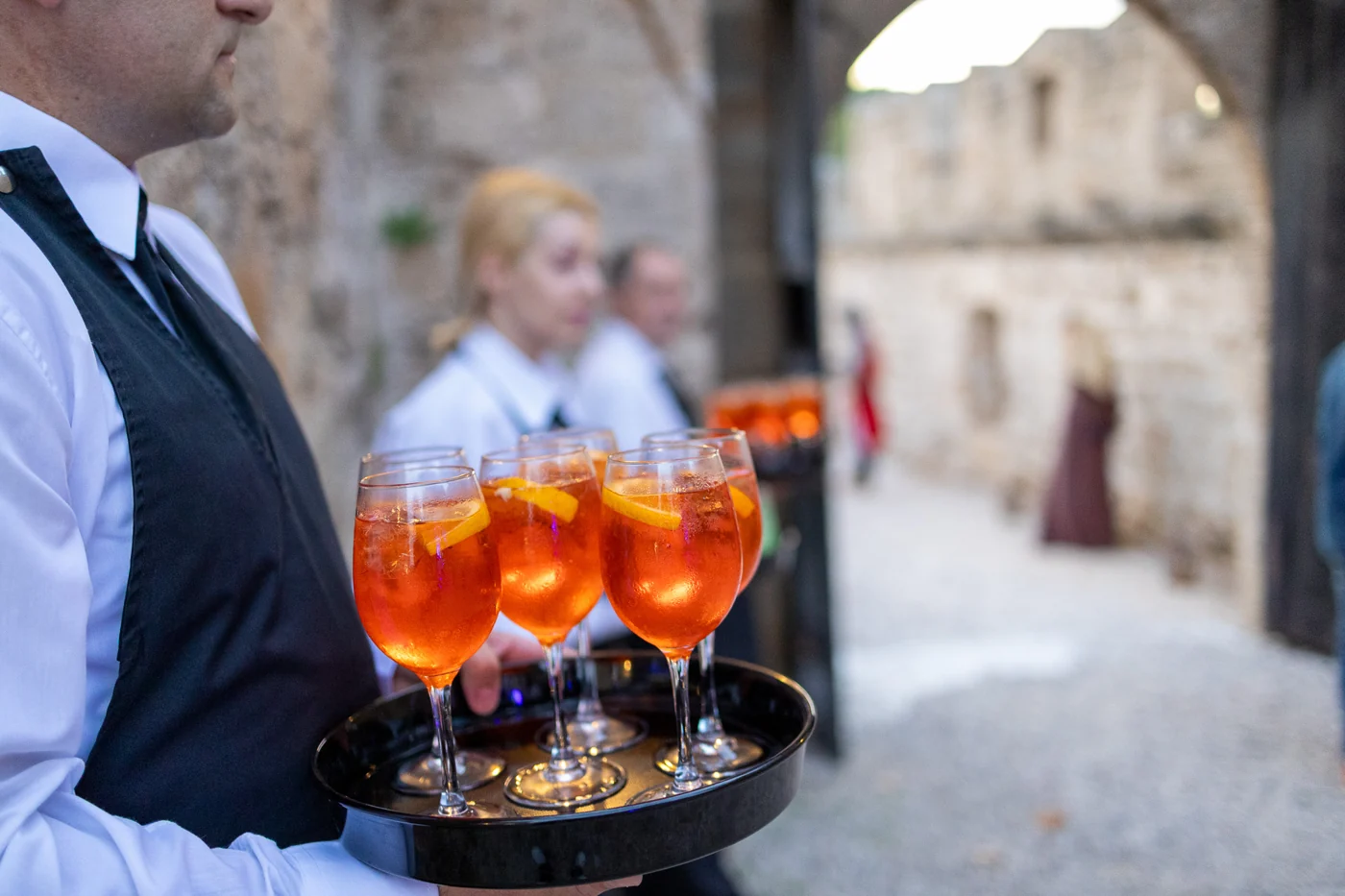 Kelner z tacą aperitifu w historycznej scenerii zamku na Rodos