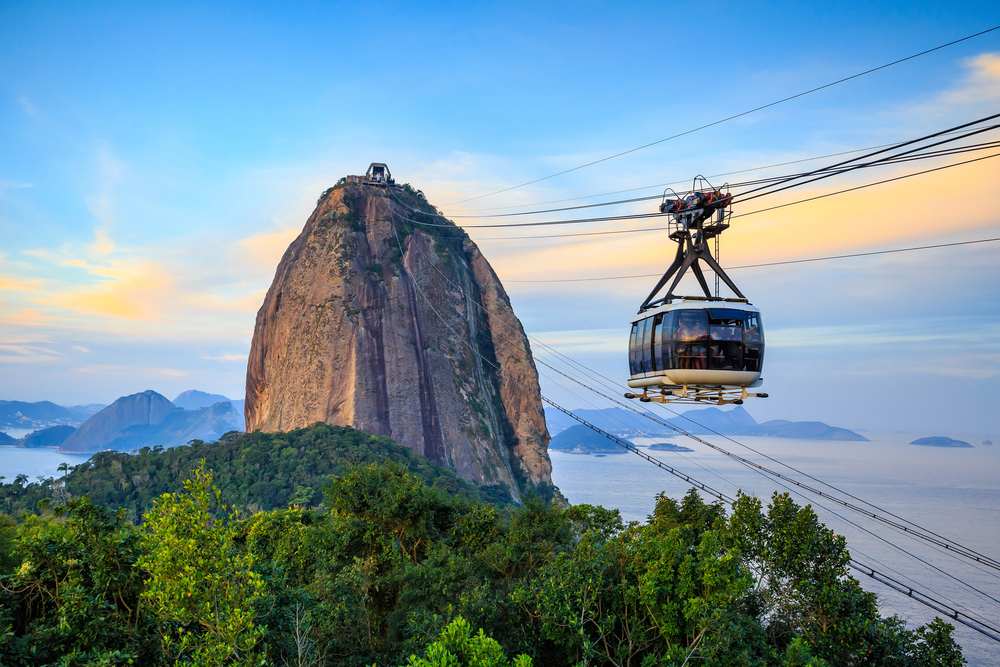 Wagonik kolejki linowej nad Rio de Janeiro z widokiem na górę Głowa Cukru i zatokę.