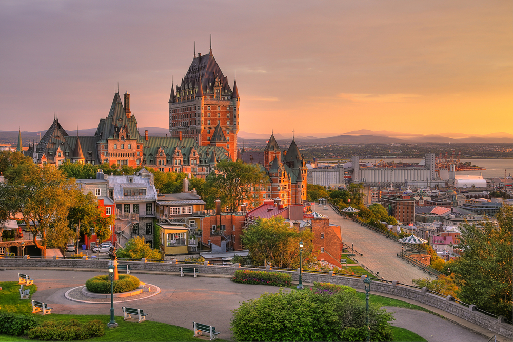 Château Frontenac i zabudowa starego Québecu w ciepłym świetle wschodzącego słońca.