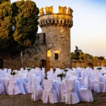 Stoły przygotowane do gali TRCO przy kamiennej wieży zamku na Rodos