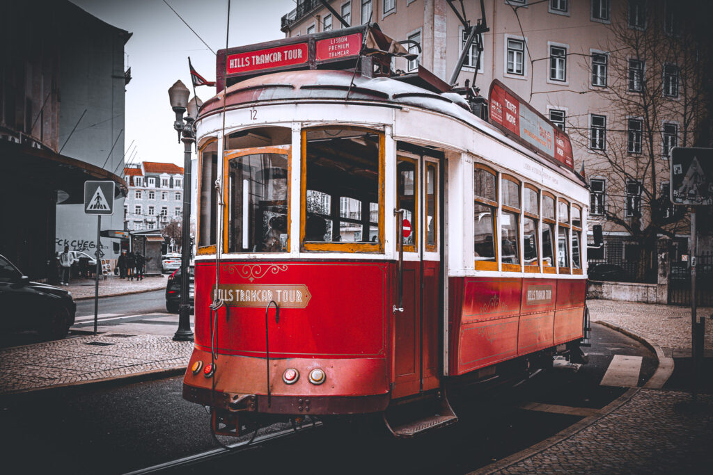 Czerwono-biały zabytkowy tramwaj na ulicy Lizbony w Portugalii.