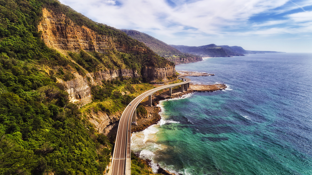 Sea Cliff Bridge na trasie Grand Pacific Drive w Australii, między zielonymi klifami a Oceanem Spokojnym.