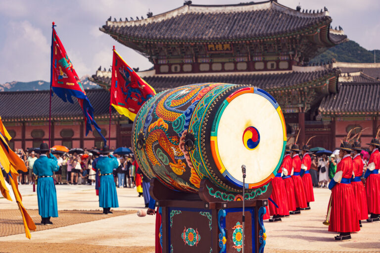 Ceremonialny bęben i strażnicy w tradycyjnych strojach przed pałacem Gyeongbokgung w Seulu.